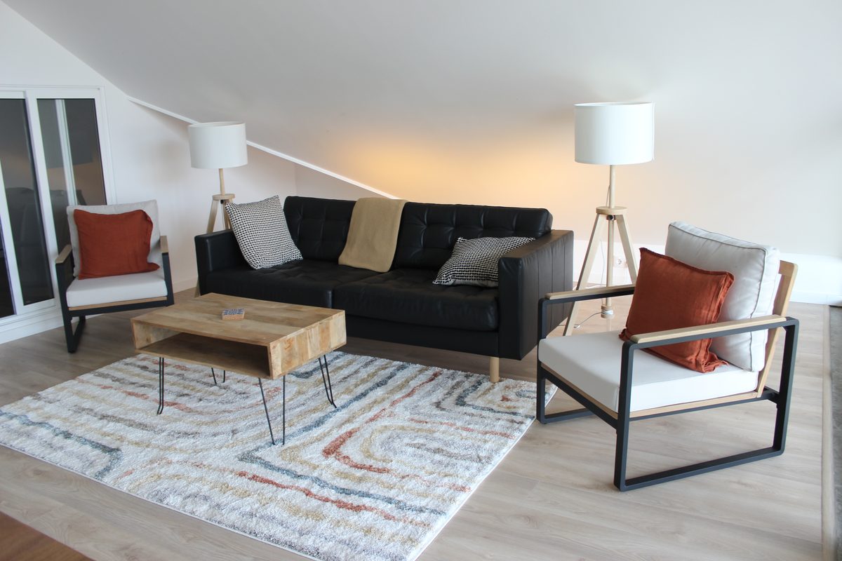 Zona de estar do piso superior, com sofá e poltronas